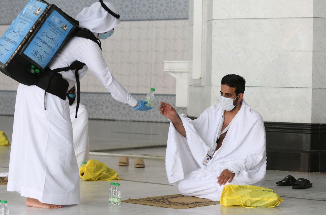 A picture taken on July 29, 2020 shows a pilgrim receiving water at the Grand Mosque complex in the holy city of Mecca.