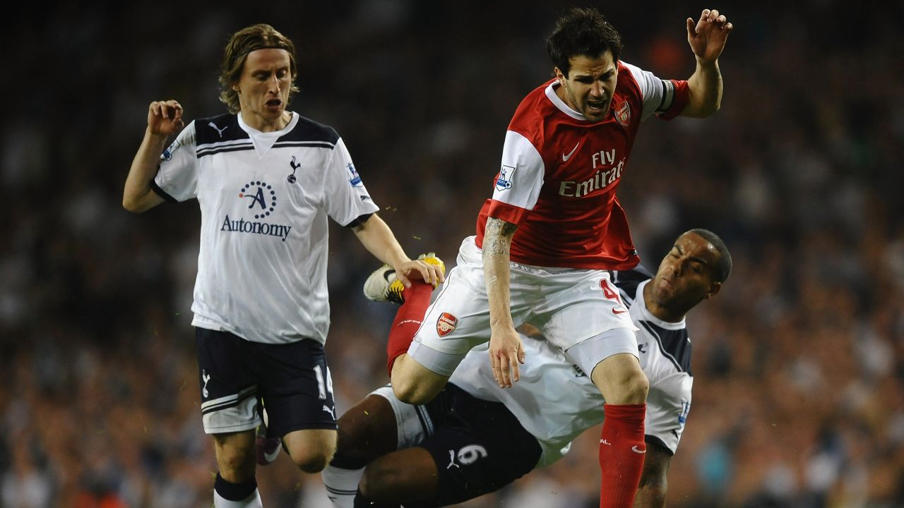 Playing for Arsenal, Fabregas is tackled by Tom Huddlestone of Spurs during the Premier League match between Tottenham Hotspur and Arsenal at White Hart Lane on April 20, 2011 in London, England.