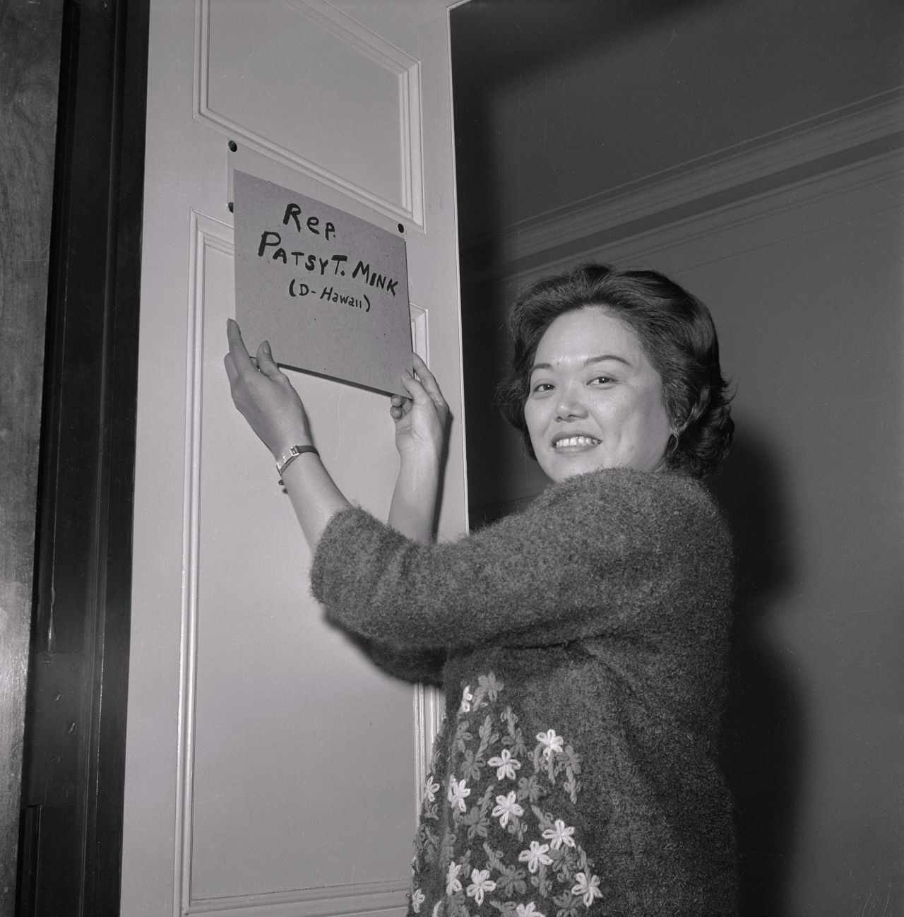 US Rep. Patsy Mink hangs a homemade nameplate on the door of her new office after becoming the first woman of color and the first Asian American woman elected to Congress in 1965. Mink's tenure in office focused on fighting for gender and racial equality. She helped author Title IX, a law prohibiting sex-based discrimination in federally funded education programs and activities.