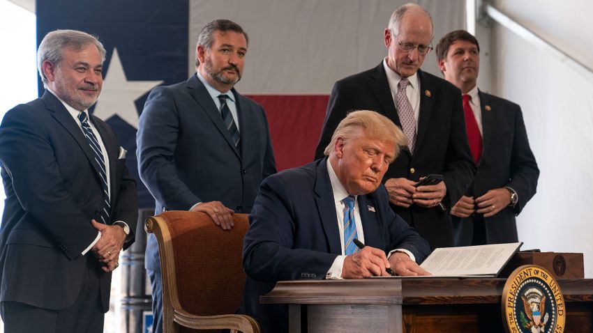 President Donald Trump signs a permit for energy development during a visit to the Double Eagle Energy Oil Rig, Wednesday, July 29, 2020, in Midland, Texas. Sen. Ted Cruz, R-Texas, stands second from left. (AP Photo/Evan Vucci)