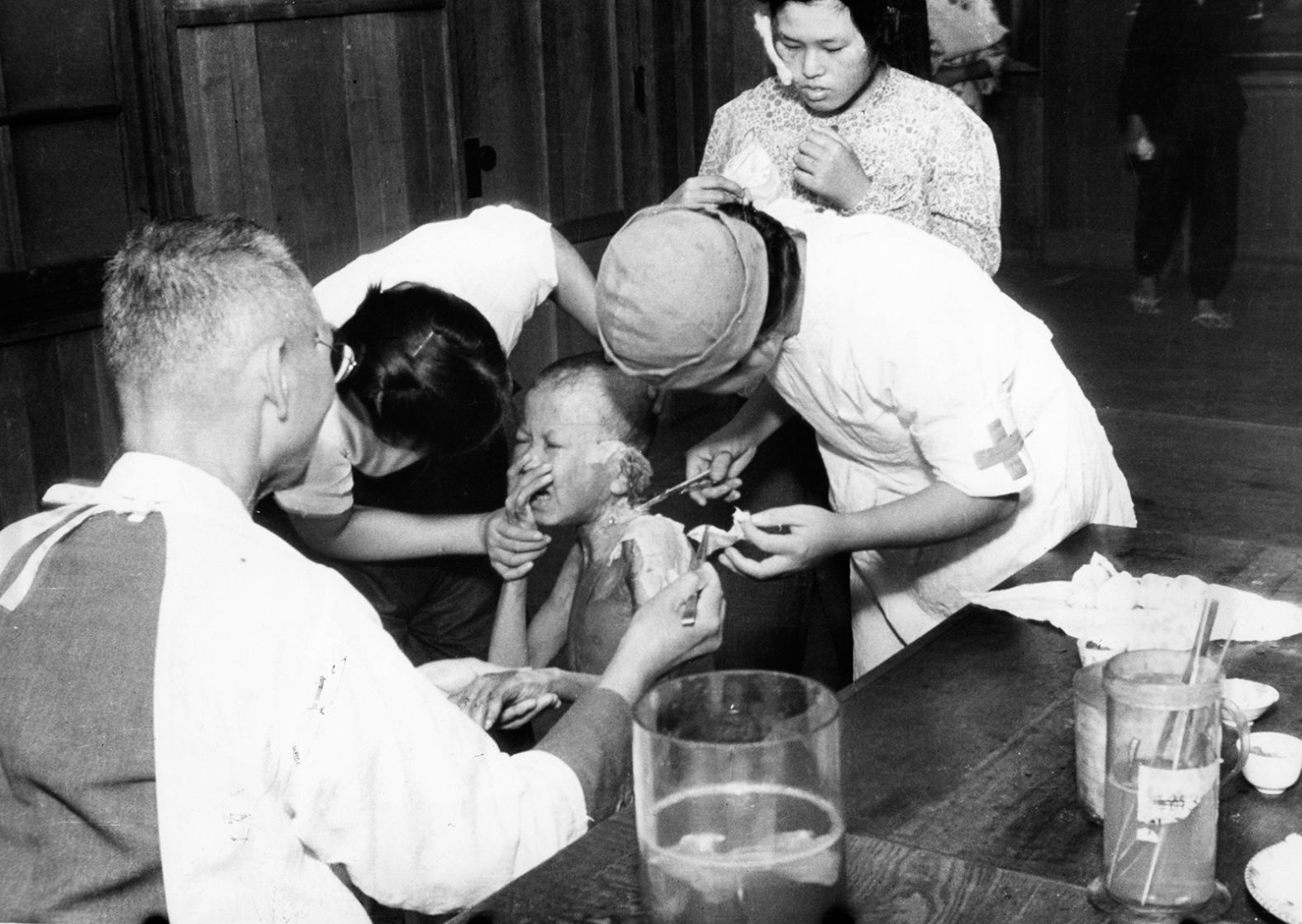 A young survivor cries as he receives treatment at a temporary hospital in Nagasaki.