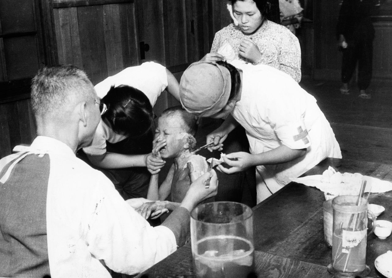A young survivor cries as he receives treatment at a temporary hospital in Nagasaki.