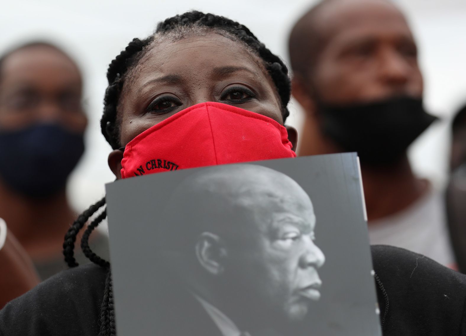 Patrice Houston holds a picture of Lewis outside the church ahead of his funeral.