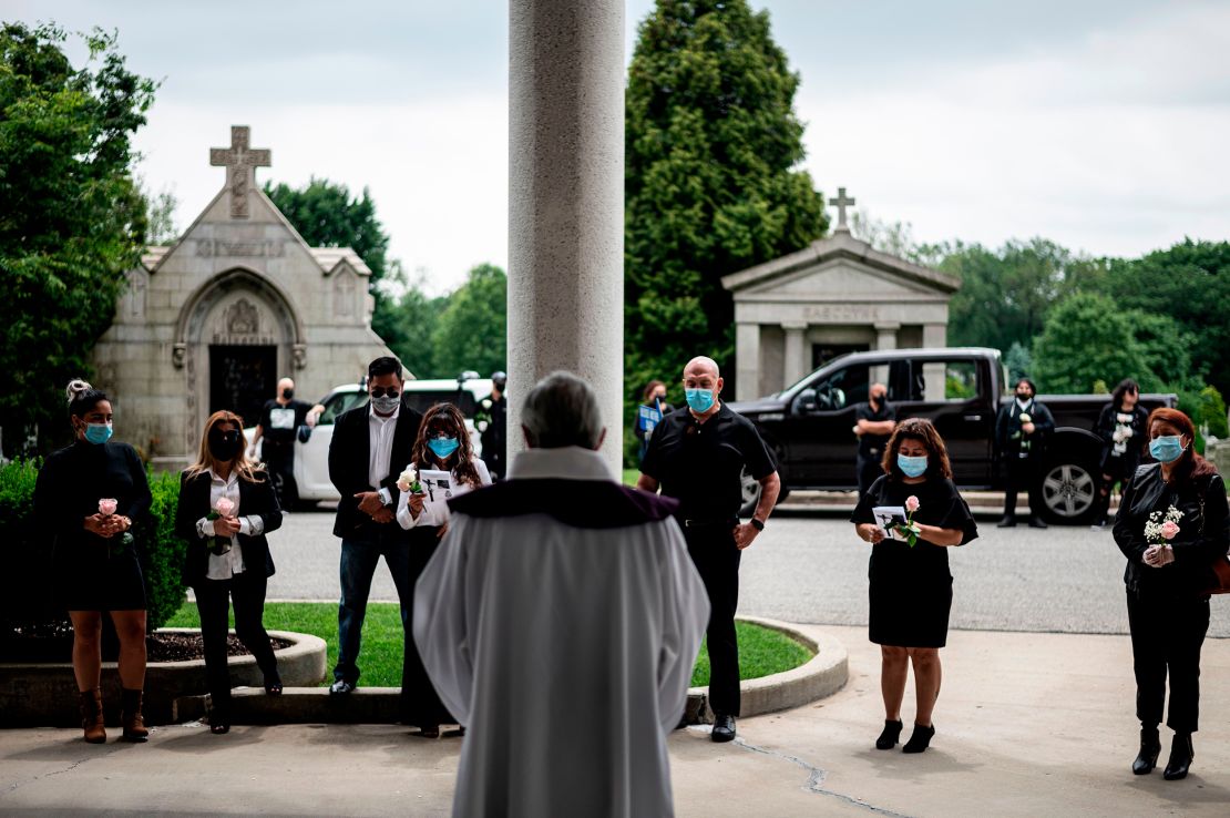 Fabian Arias (center), a Lutheran pastor with Saint Peter's Church in Manhattan, leads a funeral with the family of Francia Nelly, a woman from Ecuador who died of complications related to Covid-19, at the St. John Cemetery in Queens on June 5, 2020, in New York City.