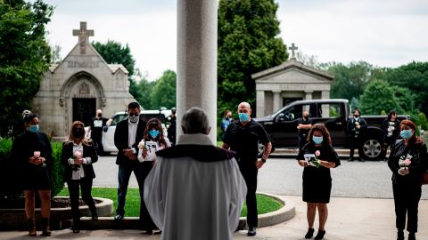 Fabian Arias (center), a Lutheran pastor with Saint Peter's Church in Manhattan, leads a funeral with the family of Francia Nelly, a woman from Ecuador who died of complications related to Covid-19, at the St. John Cemetery in Queens on June 5, 2020, in New York City. 