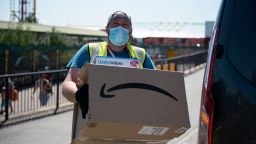 An Amazon delivery person wearing a face mask delivers a parcel along the promenade on June 25, 2020 in Southend-on-Sea, England. The UK is experiencing a summer heatwave, with temperatures in many parts of the country expected to rise above 30C and weather warnings in place for thunderstorms at the end of the week. (Photo by John Keeble/Getty Images)