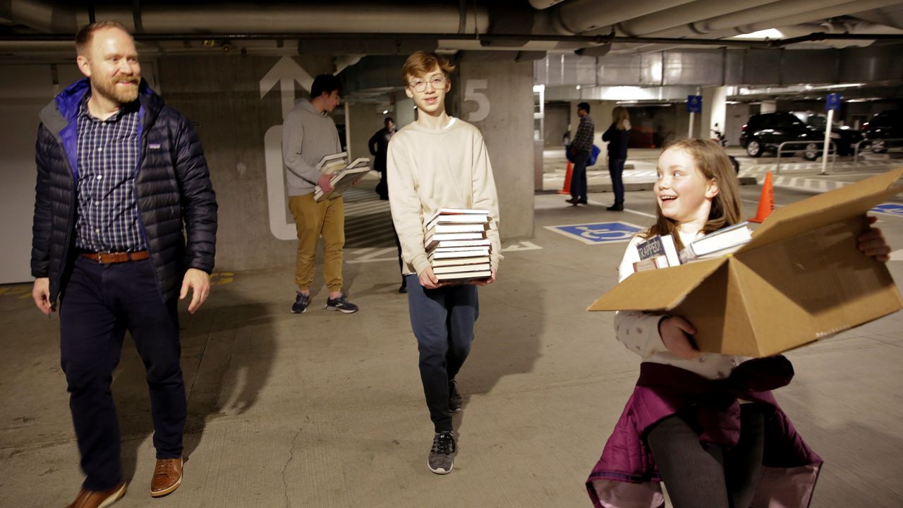 Jesse Todd of Mill Creek, Washington, walks with his kids after checking books out at the Seattle Public Library Central Branch before it closed. 