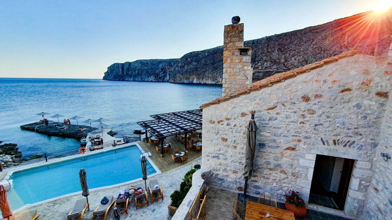 <strong>Sunset steam clean:</strong> As the last rays vanish over the imposing cliff above the coastal town of  Gerolimenas, staff at the upscale Kyrimai Hotel can be seen steam cleaning the poolside recliners.