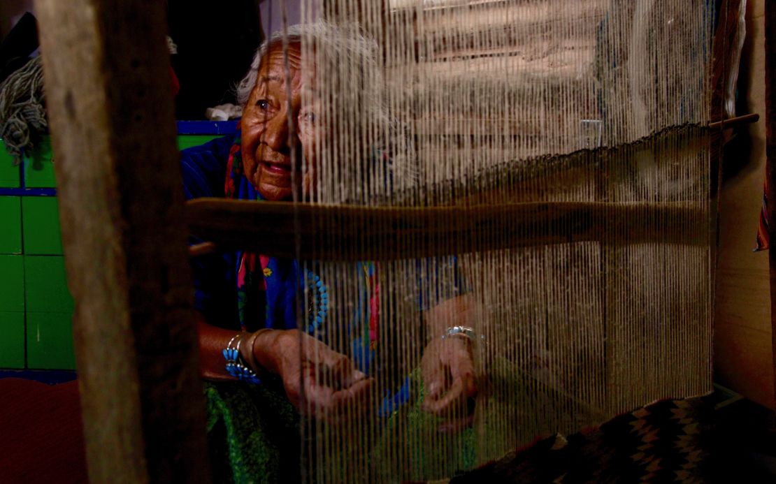 Marie Nez weaves a rug in her home on Navajo Nation.