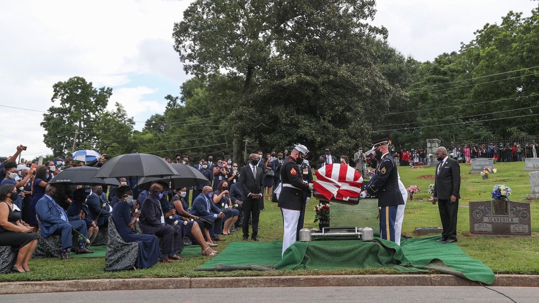 A military honor guard lowers Lewis' casket during his burial service at the South-View Cemetery in Atlanta.