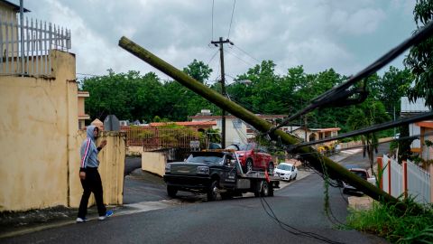 A man guides a tow truck under a downed power line pole after Tropical Storm Isaias affected the area in Mayaguez, Puerto Rico, on Thursday.