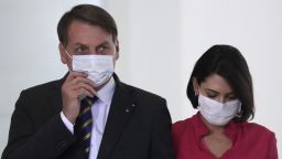 Wearing masks to curb the spread of the new coronavirus, Brazil's President Jair Bolsonaro and his wife Michelle Bolsonaro, arrive to attend the launching of a rights guarantee program for rural women, at the Planalto Presidential Palace in Brasilia, Brazil, Wednesday, July 29, 2020. (AP Photo/Eraldo Peres)