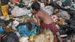 SIEM REAP, CAMBODIA - JUNE 11:  A young scavenger boy searches for plastic between tons of trash in the Anlong Pi landfill on June 11, 2014 in Siem Reap, Cambodia. Dozens of children work every day in the Anlong Pi landfill, which is situated only few kilometres aways from the world famous Angkor temples, visited by more than 3 million tourists every year. Despite the Cambodian government's commitments and legal responsibilities to end child labor - enshrined in its ratification of relevant international covenants, domestic laws and the implementation of several national policies aimed at ending child labor - it remains a significant concern in Cambodia, where almost a third of the population lives on less than a dollar per day. Child labor is a consequence of this poverty, often resulting from a family's inability to support itself. According to a recent report from the International Labour Organisation (ILO), an estimated 19.1% of the close to 4 million children in Cambodia between the ages of 5 and 17 engage in economic activities. An estimated 56.9% of those children are child labourers, with a third of them being involved in hazardous activities mostly in the agriculture, forestry and fishing sectors. (Photo by Omar Havana/Getty Images)