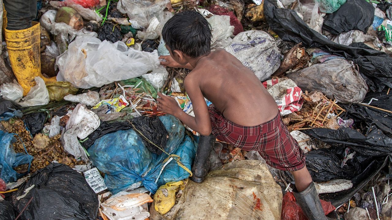 Growing up amid violence or poverty can be linked to accelerated aging, a new review of studies shows. A young boy searches for plastic in the Anlong Pi landfill in Siem Reap, Cambodia.