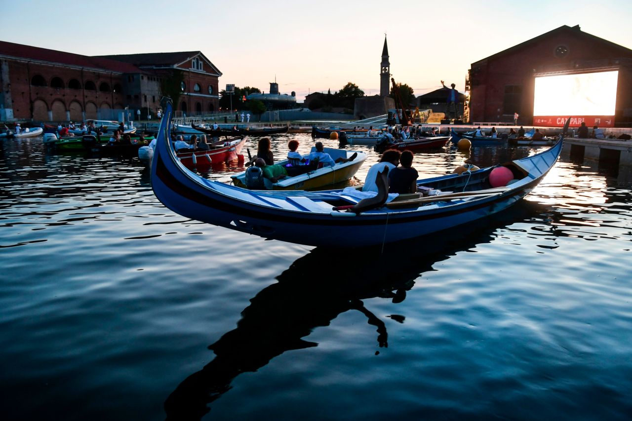 People watch the film "The Prestige" from a gondola boat in Venice, Italy, on July 28. Around the world, many films are being shown outside so that people can practice social distancing.