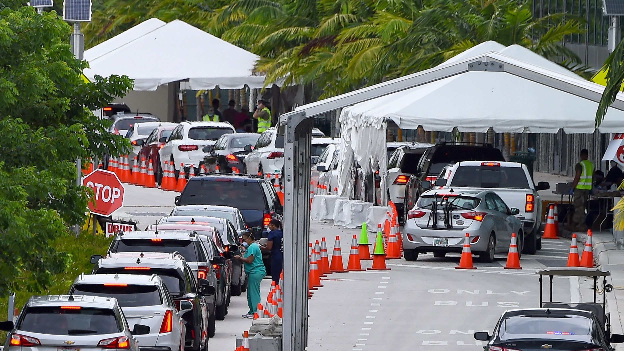 Cars line up for Covid-19 test at a "walk-in" and "drive-through" coronavirus testing site in Miami Beach, Florida on July 22, 2020.