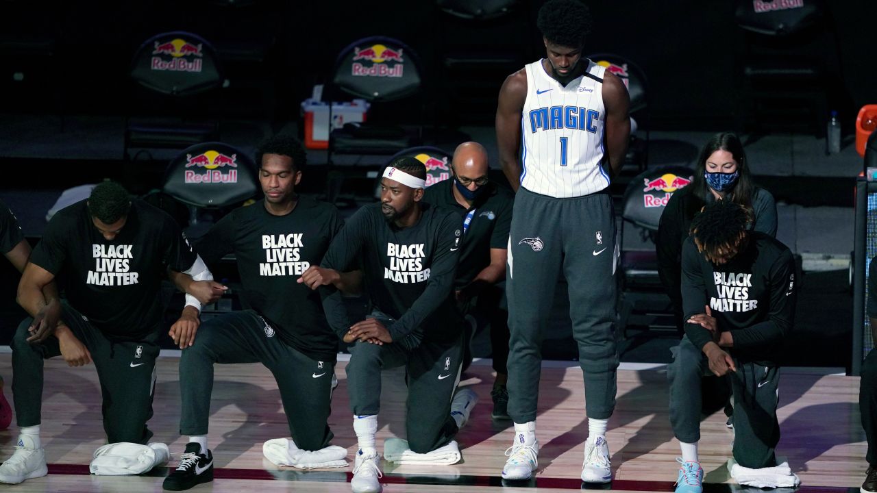 Orlando Magic forward Jonathan Isaac stands as others kneel before the start of the game between the Brooklyn Nets and the Magic on Friday.