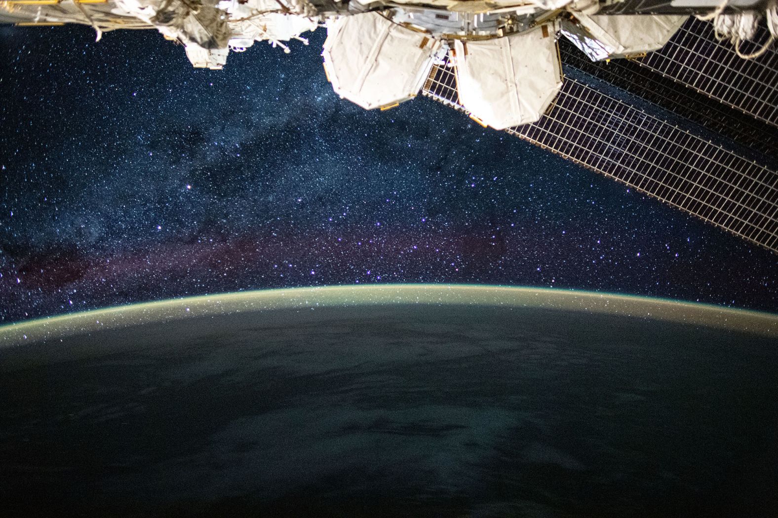 This long-exposure photograph, taken on July 24, reveals the Milky Way glittering above a bright but exaggerated atmospheric glow that blankets the Earth's horizon.