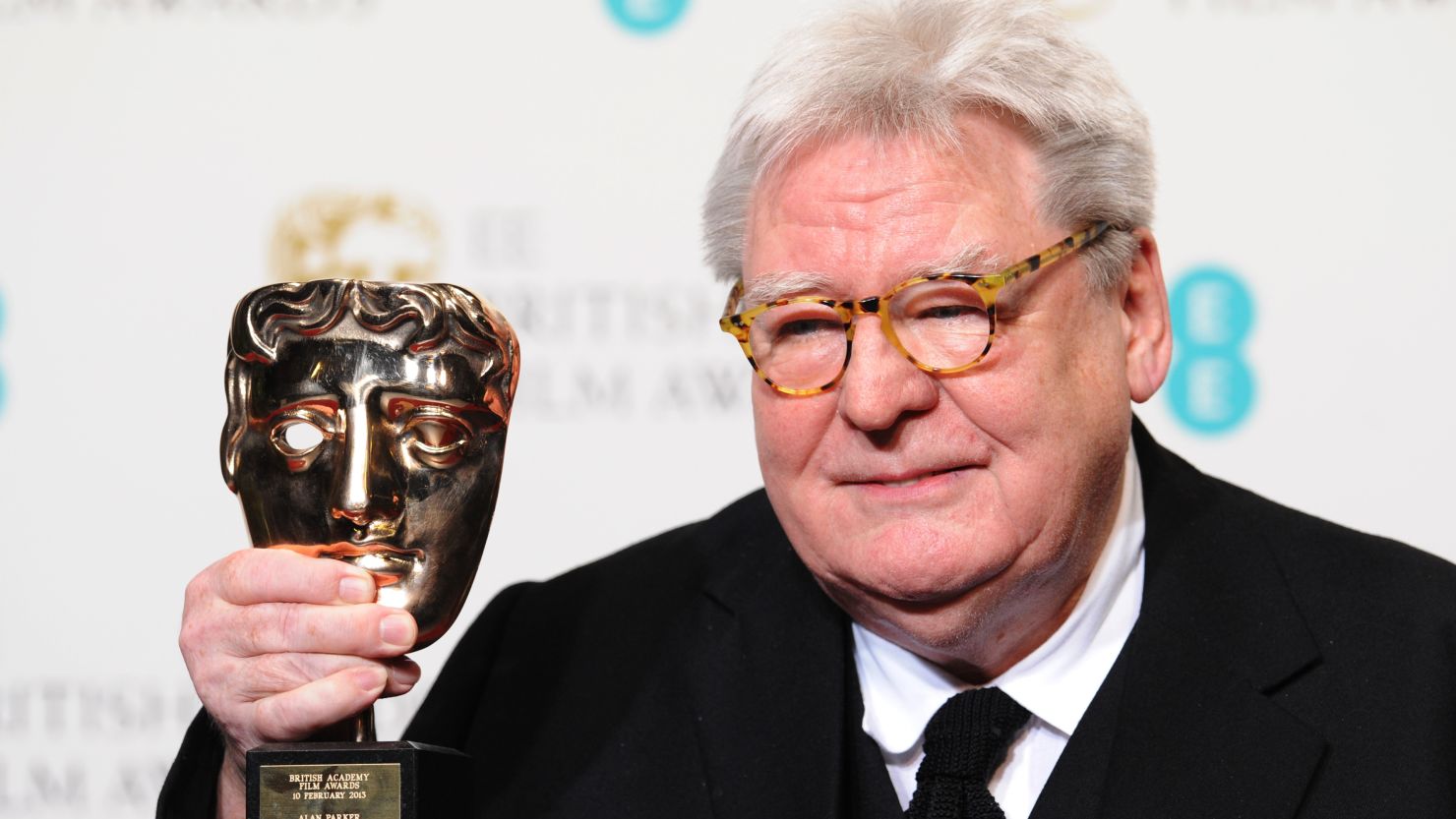 Alan Parker poses with his BAFTA Fellowship Award in 2013.