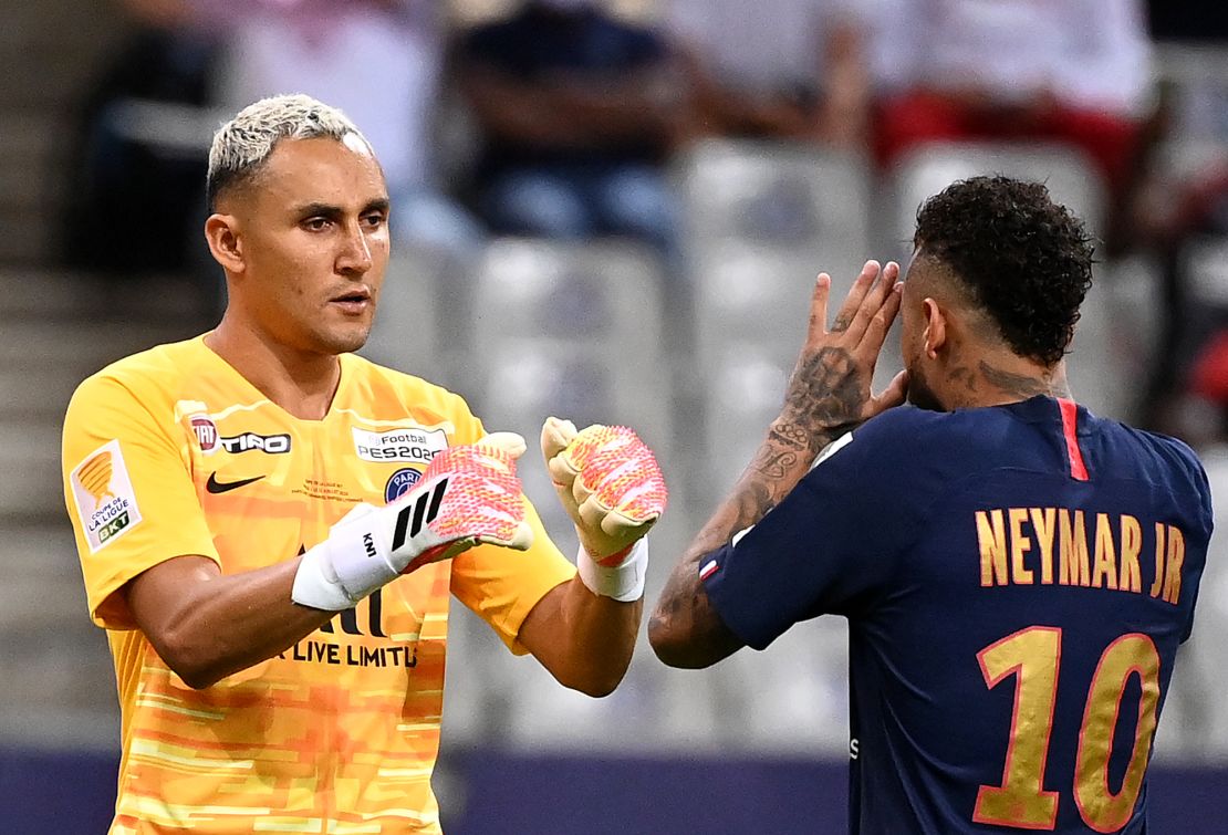 Neymar celebrates with PSG goalkeeper Keylor Navas after scoring his penalty.