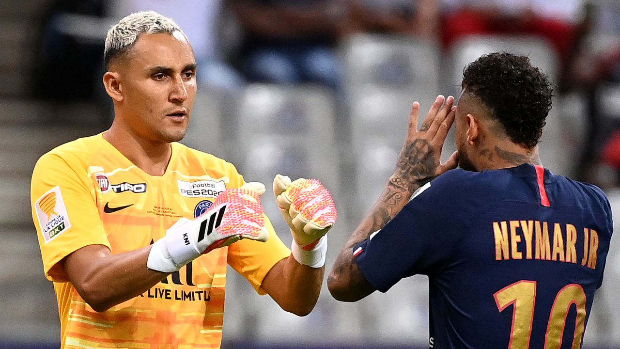 Neymar celebrates with PSG goalkeeper Keylor Navas after scoring his penalty.