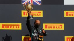 Winner Mercedes' British driver Lewis Hamilton celebrates with his trophy on the podium after the Formula One British Grand Prix at the Silverstone motor racing circuit in Silverstone, central England on August 2, 2020. - Lewis Hamilton survived a dramatic finale to win the British Grand Prix on Sunday, just making it across the line on three tyres to beat a fast closing Max Verstappen on Red Bull. The defending world champion claimed his seventh British Grand Prix win as Ferarri's Charles Leclerc came third and Daniel Ricciardo of Renault fourth. (Photo by Frank Augstein / POOL / AFP) (Photo by FRANK AUGSTEIN/POOL/AFP via Getty Images)