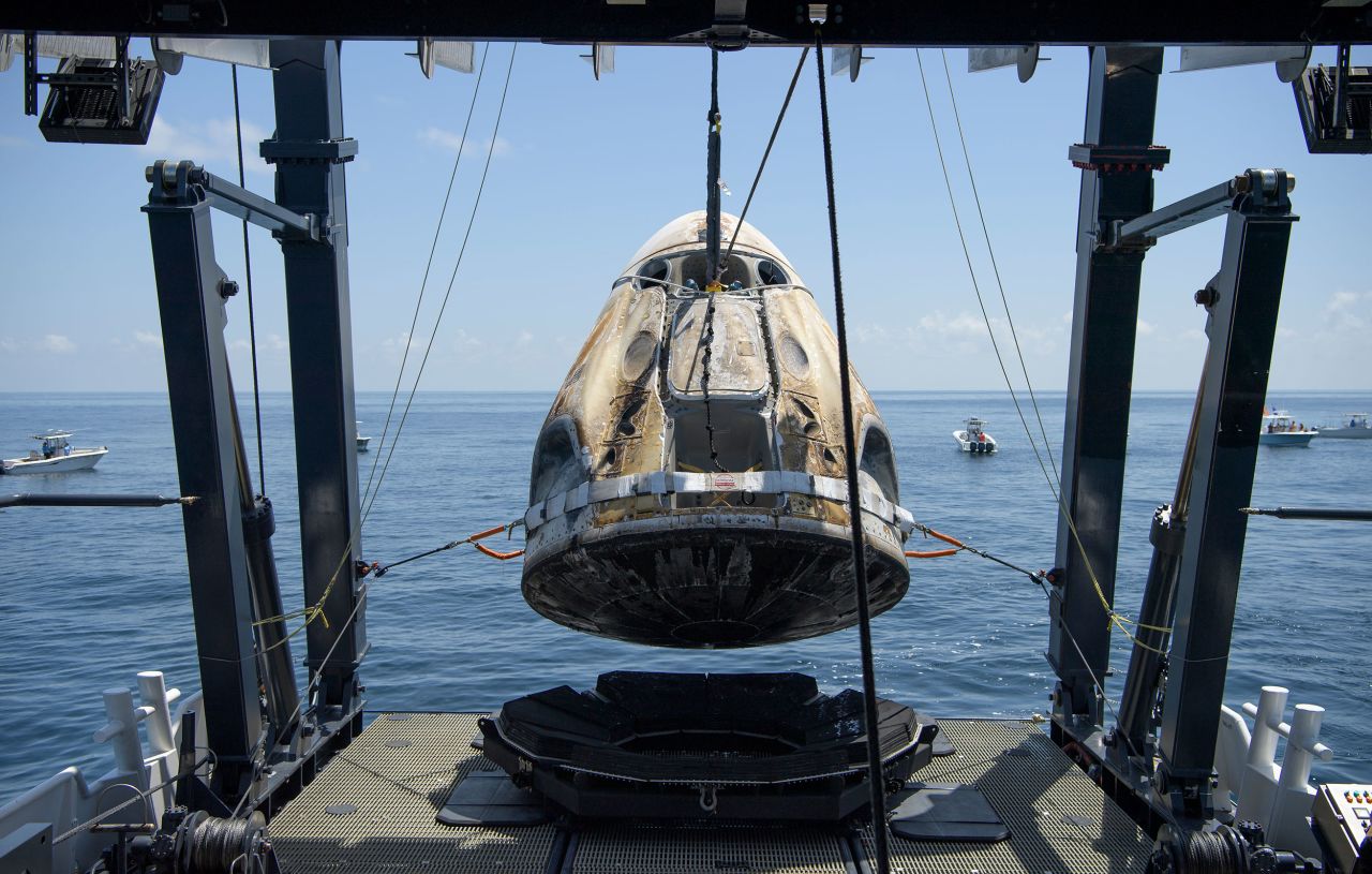The Crew Dragon spacecraft is lifted onto a recovery ship shortly after splashdown.