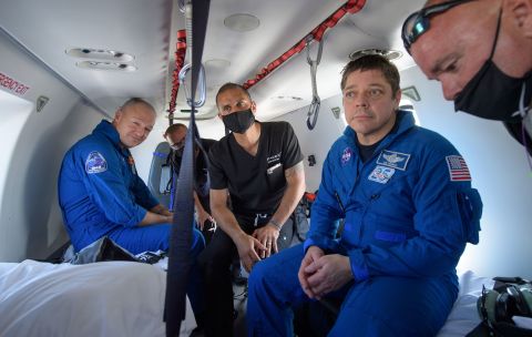 Hurley, left, and Behnken, second from right, ride in a helicopter after returning from space.