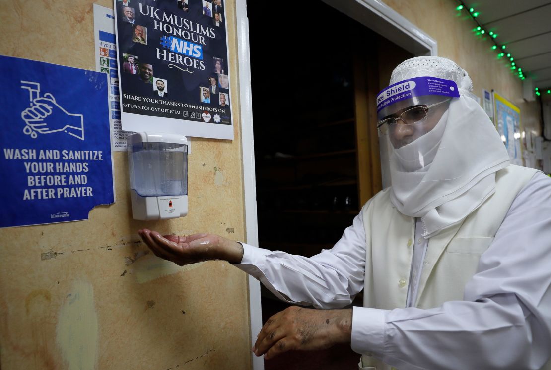 A volunteer uses hand sanitizer as he enters Minhaj-ul-Quran Mosque in London on July 31.