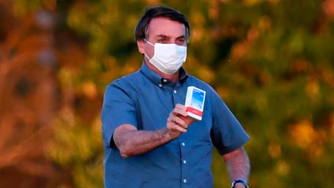 Brazilian President Jair Bolsonaro shows a box of hydroxychloroquine to supporters outside the Alvorada Palace in Brasilia, on July 23, 2020.