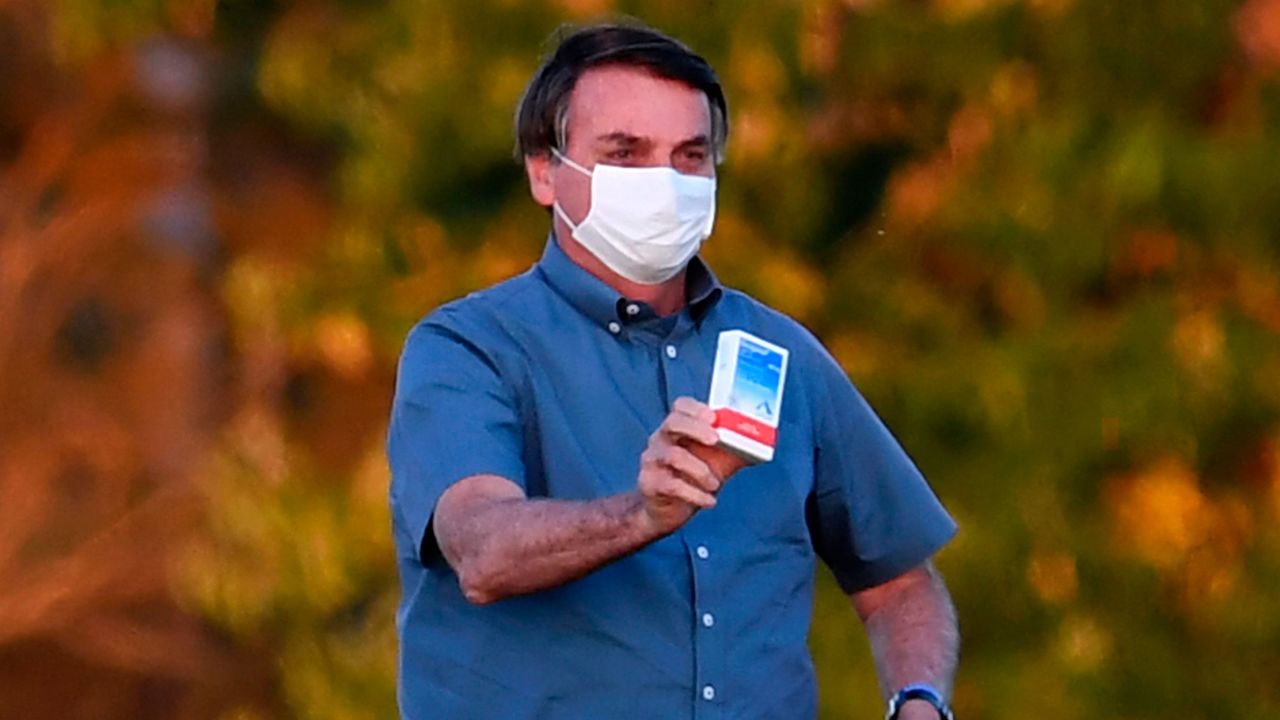 Brazilian President Jair Bolsonaro shows a box of hydroxychloroquine to supporters outside the Alvorada Palace in Brasilia, on July 23, 2020.