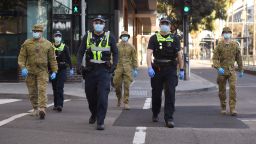 A group of police and soldiers patrol the Docklands area of Melbourne on August 2, 2020, after the announcement of new restrictions to curb the spread of the COVID-19 coronavirus. - Australia on August 2 introduced sweeping new measures to control a growing coronavirus outbreak in its second-biggest city, including an overnight curfew and a ban on weddings for the first time during the pandemic. (Photo by William WEST / AFP) (Photo by WILLIAM WEST/AFP via Getty Images)