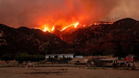 Flames from the Apple fire skirt a ridge in a residential area of Banning, California on August 1, 2020. 