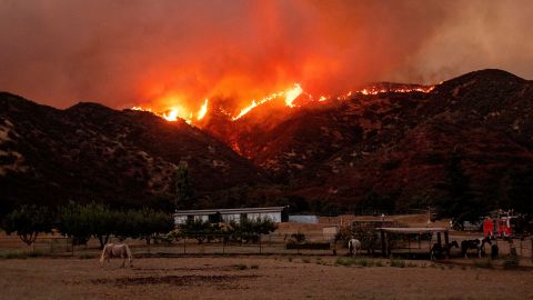Flames from the Apple fire skirt a ridge in a residential area of Banning, California on August 1, 2020.
