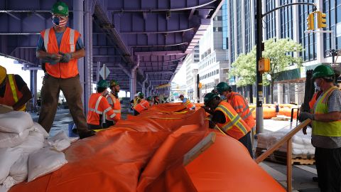 New York City workers erect flood barriers to protect against an expected storm surge.