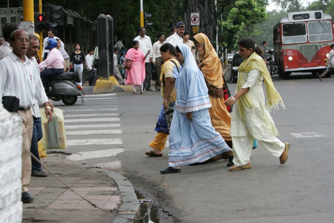 Pedestrians cross a street in Mumbai. 