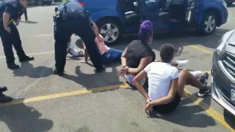 A Facebook video shows the children on the ground in a parking lot, surrounded by police.