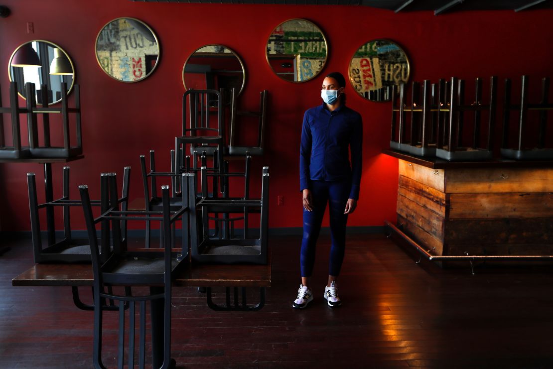 Stephanie Byrd, co-owner of The Block, poses for a photo with chairs on the tables while the restaurant is closed due to the coronavirus in Detroit on May 21, 2020.