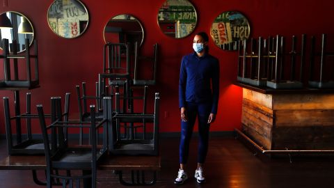 Stephanie Byrd, co-owner of The Block, poses for a photo with chairs on the tables while the restaurant is closed due to the coronavirus in Detroit on May 21, 2020.