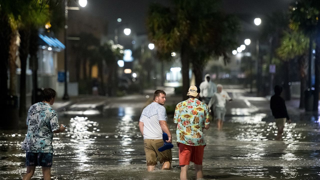 People walk through floodwaters Monday in Myrtle Beach, South Carolina.