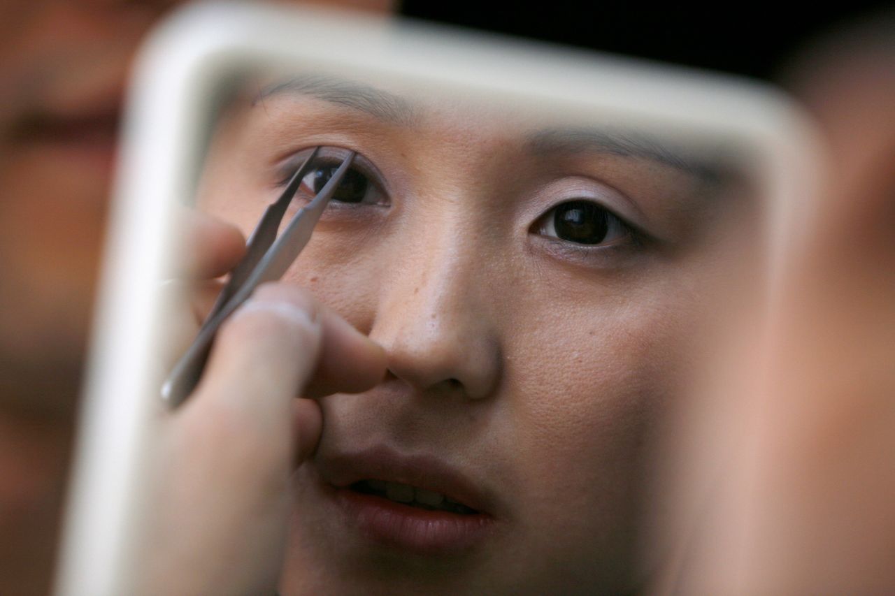 Korean plastic surgeon Kim Byung-gun (not pictured) demonstrates the effect of "double eyelid surgery," which adds a crease to the eyelids to make the patient's eyes appear larger.