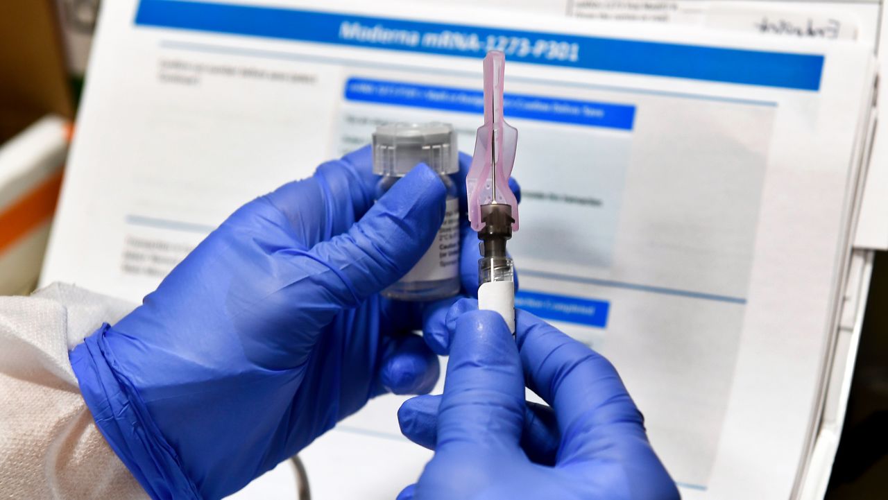 Nurse Kathe Olmstead prepares a shot as the world's biggest study of a possible COVID-19 vaccine, developed by the National Institutes of Health and Moderna Inc., gets underway Monday, July 27, 2020, in Binghamton, N.Y. (AP Photo/Hans Pennink)