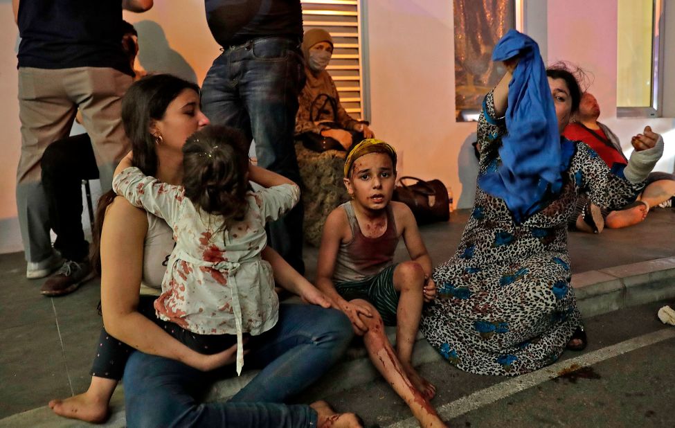 Wounded people wait to receive help outside a hospital. Emergency wards were inundated.