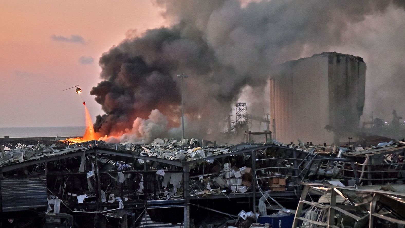 A helicopter fights a fire at the scene of the explosion.