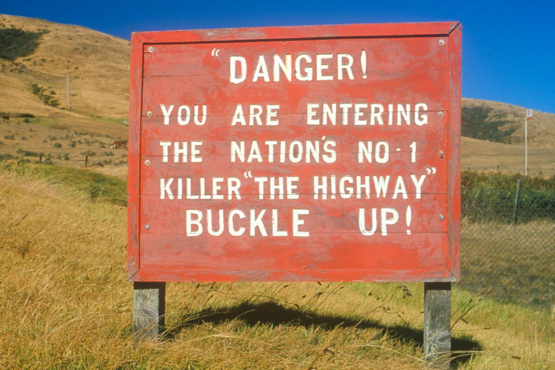 A road sign warns drivers to wear their seat belt. 