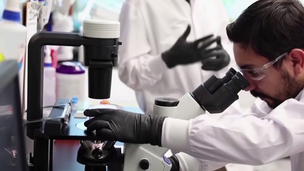 A screenshot of a researcher in a lab taken from Anna Stewart's package on whether people can be reinfected by Covid-19.