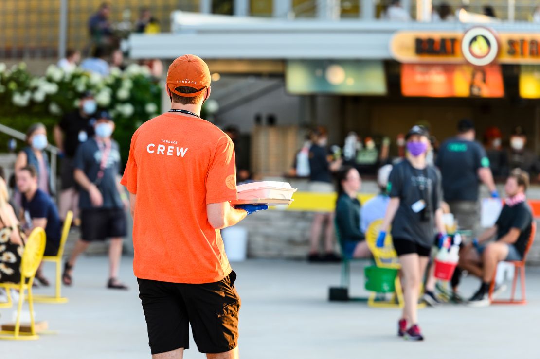 A Wisconsin Union staff member carries a food order to diners.