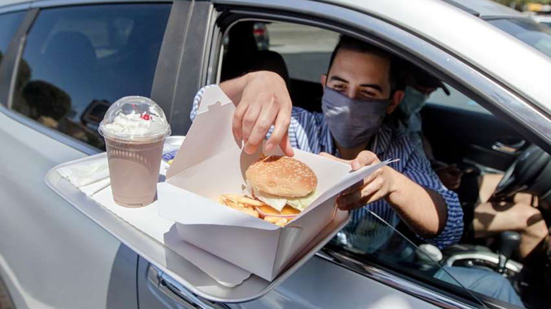 <strong>What's old is new again: </strong>A diner digs into a burger from his car at Mel's Drive In. 