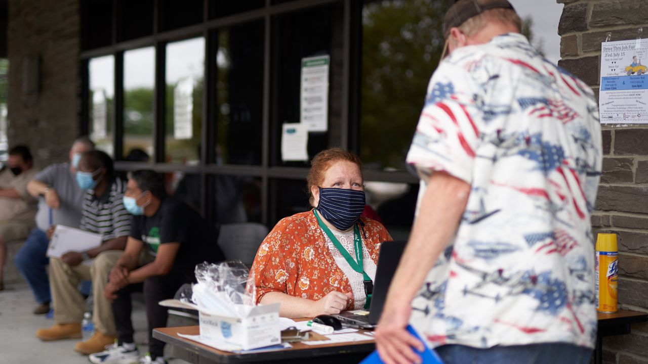 One-stop operator Vickie Gregorio with the Heartland Workforce Solutions talks to a job seeker outside the workforce office in Omaha, Neb., Wednesday, July 15, 2020, as others seeking employment wait behind her. Nebraska reinstated job search requirements this week for most people claiming jobless benefits. Those unemployment insurance requirements were suspended in mid-March to help employees who had lost their jobs due to the Covid-19 coronavirus. (AP Photo/Nati Harnik)