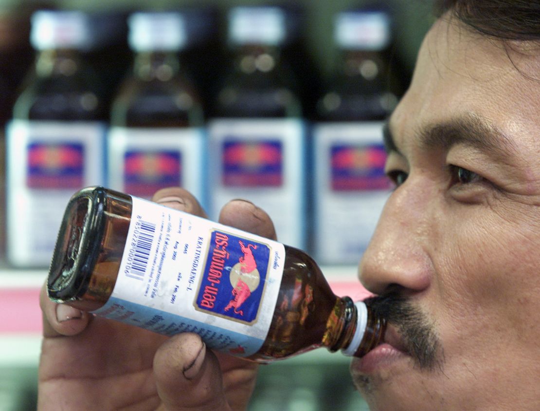 A Thai man drinks a bottle of Krating Daeng, an original Thai version
of popular drink Red Bull, in a store in Bangkok in July 2001.